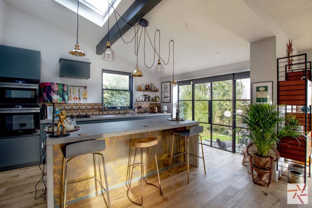 Modern kitchen with steel-framed glazed screen partition, showcasing natural light and open concept design